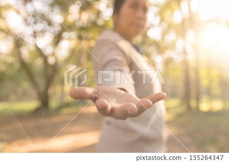 Outstretched hand reaching toward camera in sunny park with soft bokeh, inviting help and connection. Warm backlight, shallow focus, copy space for support, trust, kindness, community and care. Outstretched hand reaching toward camera in sunny park with soft bokeh, inviting help and connection. Warm backlight, shallow focus, copy space for support, trust, kindness, community and care. 135264347