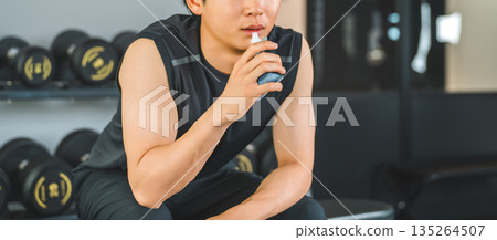 一名年輕的亞洲男子在健身房運動後喝果凍飲料補充能量。 135264507