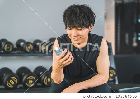 Young Asian man drinking jelly drink to refuel after training at the gym Young Asian man drinking jelly drink to refuel after training at the gym 135264510