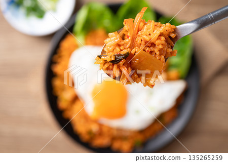 Korean kimchi fried rice with fried egg eating by spoon, Close up Korean kimchi fried rice with fried egg eating by spoon, Close up 135265259