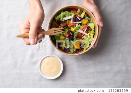 Healthy vegetable salad in takeout bowl eating with salad dressing Healthy vegetable salad in takeout bowl eating with salad dressing 135265269