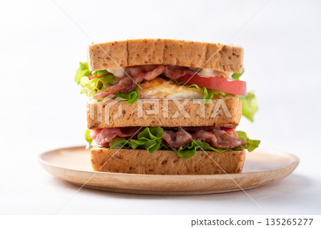 Whole wheat bread sandwich with bacon, lettuce, tomato and fried egg Whole wheat bread sandwich with bacon, lettuce, tomato and fried egg 135265277
