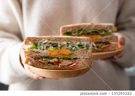 Whole wheat bread sandwich with bacon, lettuce, tomato and fried egg Whole wheat bread sandwich with bacon, lettuce, tomato and fried egg 135265282