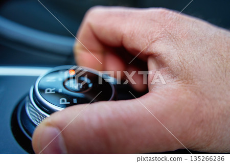 Driver hand turning automatic gear selector in car Driver hand turning automatic gear selector in car 135266286