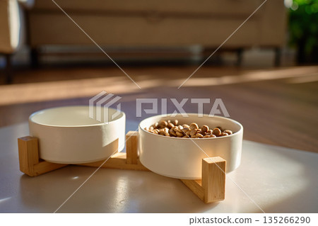 Dog food bowls with dry kibble on floor at home Dog food bowls with dry kibble on floor at home 135266290
