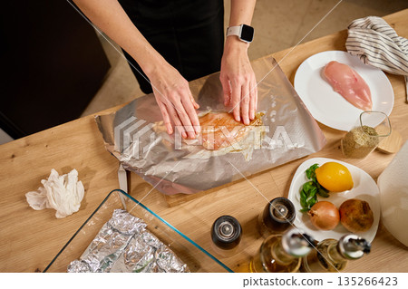 Marinating raw chicken breast on foil in home kitchen 135266423
