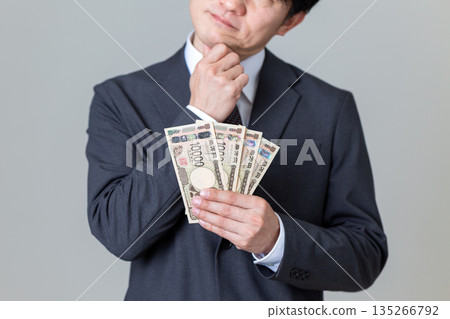 A middle-aged male businessman in a suit who is worried about money A middle-aged male businessman in a suit who is worried about money 135266792