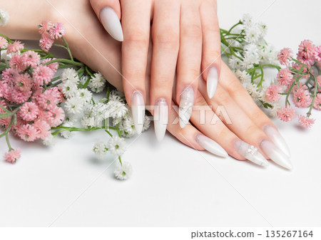 Woman showing hands with long white ombre nails Woman showing hands with long white ombre nails 135267164