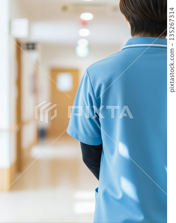 Back view of a Japanese caregiver standing in the corridor of a nursing home 135267314