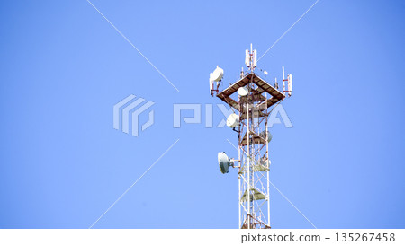 A tall tower with many antennas on top of it 135267458