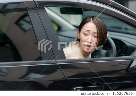A woman struggling to park her car A woman struggling to park her car 135267636