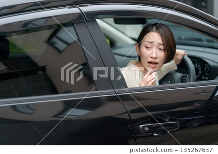 A woman struggling to park her car A woman struggling to park her car 135267637