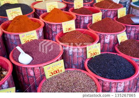 A vibrant market stall showcases a variety of colorful spices, each piled high in individual containers, creating a visually appealing display. A vibrant market stall showcases a variety of colorful spices, each piled high in individual containers, creating a visually appealing display. 135267865
