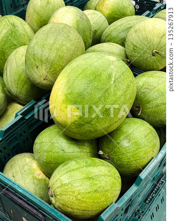 Fresh watermelons stacked in crates at a market. Fresh watermelons stacked in crates at a market. 135267913