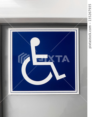 Wheelchair accessibility sign on a blue and white background. Wheelchair accessibility sign on a blue and white background. 135267935
