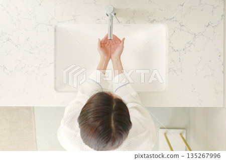 俯視視角,一名女子身穿浴袍洗手。 俯視視角,一名女子身穿浴袍洗手。 135267996