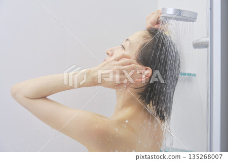 Woman rinsing her hair in the shower Woman rinsing her hair in the shower 135268007