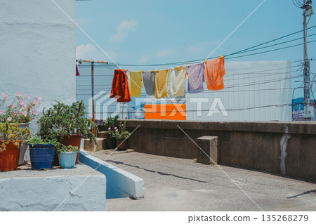 Korean Alleyway Scene with Colorful Laundry and Potted Plants Korean Alleyway Scene with Colorful Laundry and Potted Plants 135268279