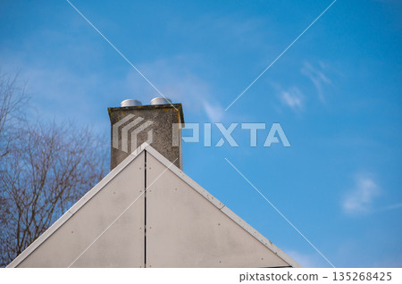 House Roof and Chimney Against Clear Blue Sky House Roof and Chimney Against Clear Blue Sky 135268425