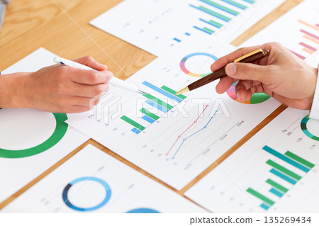 Businessmen having a meeting while looking at many graphs Businessmen having a meeting while looking at many graphs 135269434