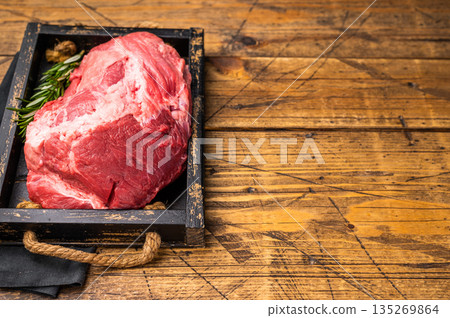 Raw beef boneless shank meat with visible marbling, ready for braising or roasting, offering a flavorful addition to any gourmet dish or family dinner. wooden background. top view 135269864