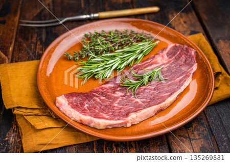 Uncooked sirloin cut, raw beef steak known for its tenderness and robust flavor. wooden background. top view Uncooked sirloin cut, raw beef steak known for its tenderness and robust flavor. wooden background. top view 135269881