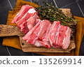 Fresh lamb rack rib pieces, mutton meat with thyme on wooden board. black background. top view 135269914