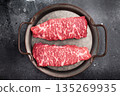 Premium denver, chuck eye steak, beautifully presented, ready for seasoning. A versatile cut ideal for barbecue enthusiasts and steak lovers alike. black background. top view 135269935