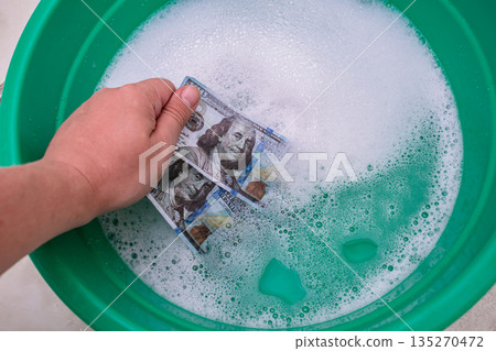 Conceptual. Symbolic money laundering in a basin of soapy water Conceptual. Symbolic money laundering in a basin of soapy water 135270472
