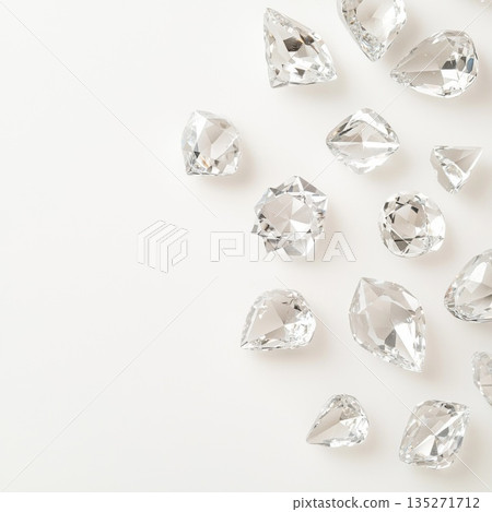 Sparkling faceted diamonds in different cuts and sizes scattered artfully on pristine white surface, highlighting brilliant gemstone luxury and brilliance 135271712