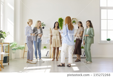 Womens group meeting in modern office, facilitator leading engaging team training Womens group meeting in modern office, facilitator leading engaging team training 135272268