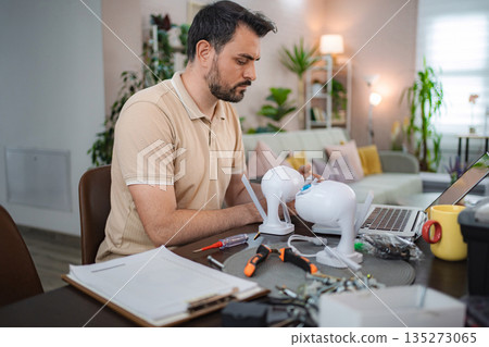 Technician installing surveillance camera system at home using laptop Technician installing surveillance camera system at home using laptop 135273065