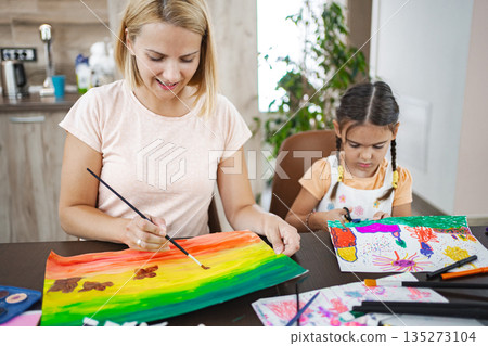A mother and daughter creating colorful artwork together at home in the afternoon A mother and daughter creating colorful artwork together at home in the afternoon 135273104