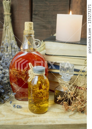 Healing herbal remedies, ancient books, bouquets of mystical herbal potions and candles on wooden background Healing herbal remedies, ancient books, bouquets of mystical herbal potions and candles on wooden background 135273271