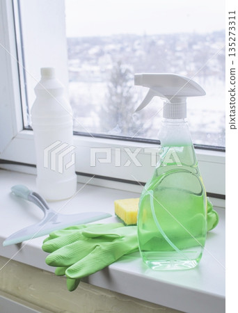 Window cleaning products on a windowsill with a view of a snowy winter 135273311