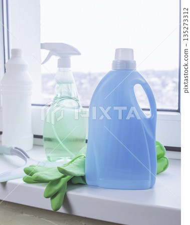 Window cleaning products on a windowsill with a view of a snowy winter 135273312