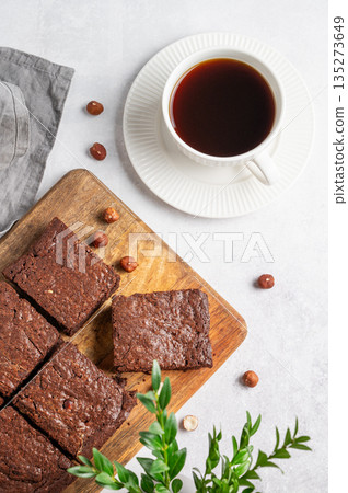 Pieces of chocolate brownie on a wooden board and a cup of espresso coffee on a light background 135273649
