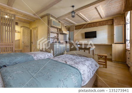 Cozy rustic studio interior with twin beds and wooden kitchen Cozy rustic studio interior with twin beds and wooden kitchen 135273941