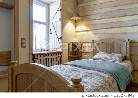 Cozy rustic bedroom corner with wooden bed and warm lighting Cozy rustic bedroom corner with wooden bed and warm lighting 135273942