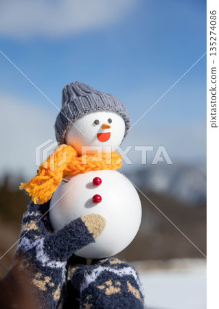 Holding a snowman Holding a snowman 135274086