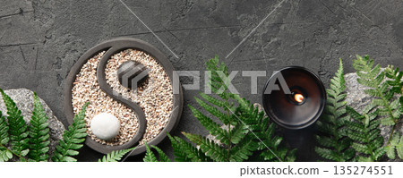 Yin Yang Zen Garden with Candle and Fern on Dark Stone Background 135274551