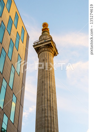 The Monument to the Great Fire of London stands tall near modern buildings, highlighting the contrast between history and contemporary architecture. The Monument to the Great Fire of London stands tall near modern buildings, highlighting the contrast between history and contemporary architecture. 135274619