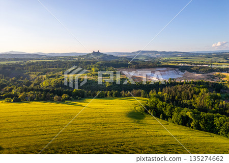 The beauty of Bohemian Paradise in Czechia during summer. Trosky Castle towers over the countryside, surrounded by lush greenery and rolling hills. The beauty of Bohemian Paradise in Czechia during summer. Trosky Castle towers over the countryside, surrounded by lush greenery and rolling hills. 135274662