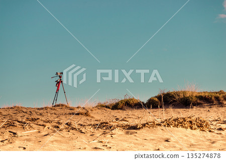 Camera on sand beach taking picture film Camera on sand beach taking picture film 135274878