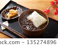 Steaming red bean soup and pickles on a Japanese tray placed on a wooden table 135274896