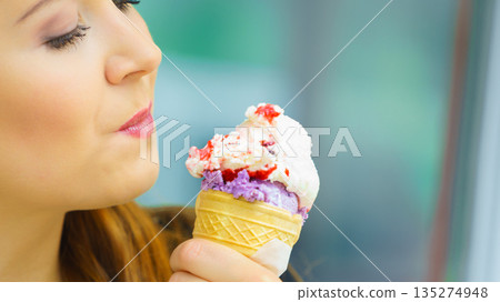 Young woman eating ice cream 135274948