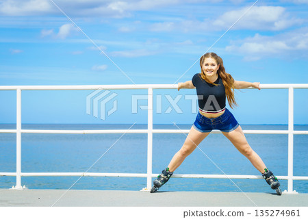 Girl wearing roller skates on seaside 135274961