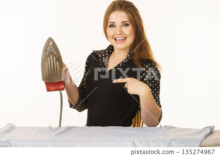 Happy woman doing ironing Happy woman doing ironing 135274967