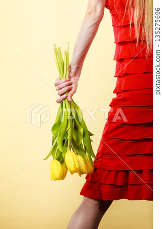 Woman wearing dress holding tulip Woman wearing dress holding tulip 135275696