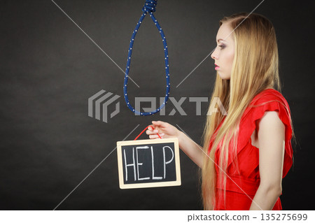 Suicidal woman holding help sign next to rope 135275699